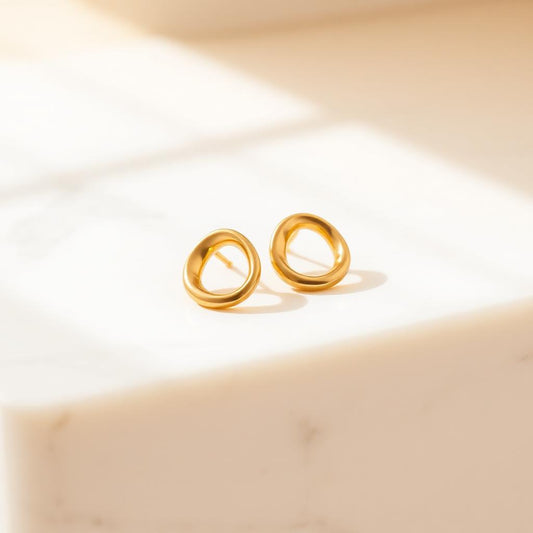 Yellow gold molten studs on warm marble