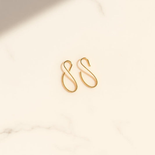 Yellow gold threader earrings on warm marble