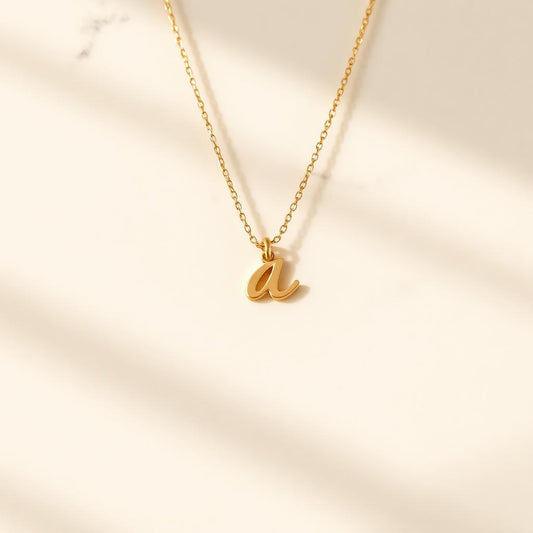Yellow gold initial pendant on warm marble